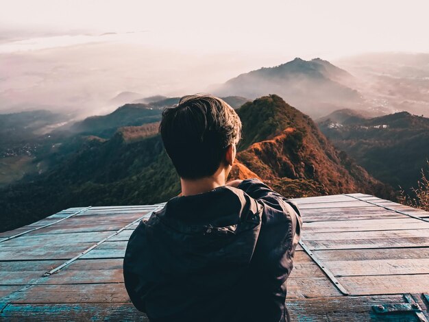 写真 山脈を眺めている少年の後ろの景色