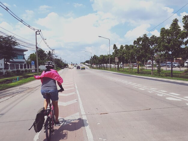 사진 도시 의 도로 에서 자전거 를 타고 다니는 소년 의 뒷면