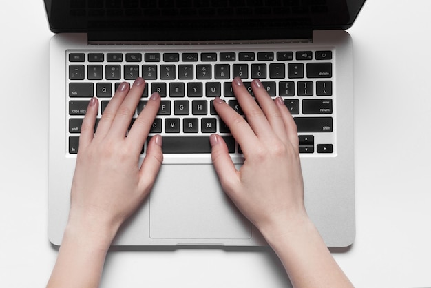 Фото Вид сзади на руки деловой женщины, занятые использованием ноутбука за офисным столом с копирайтом