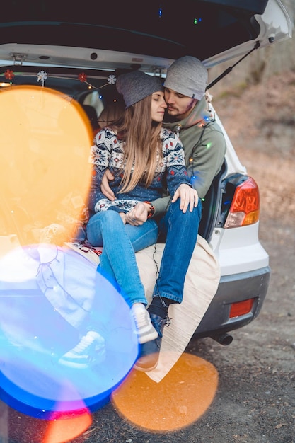 写真 車に座っている夫婦の後ろの景色