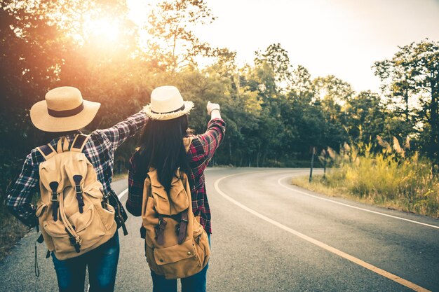 写真 道に立っているバックパックを背負ったカップルの後ろの景色