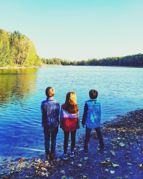 Фото Сзади друзей, стоящих на берегу озера