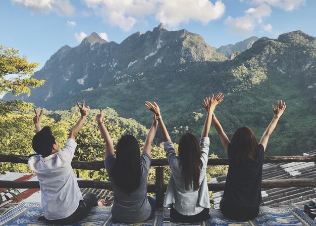 사진 산 에 맞춰 앉아 있는 팔 을 들고 있는 친구 들 의 뒷면