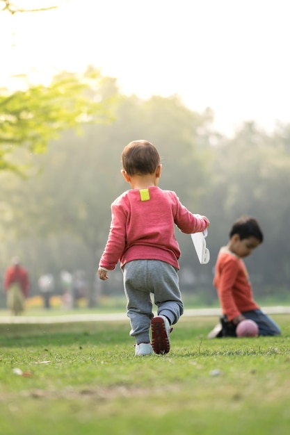 写真 公園で弟と一緒にいる女の子の後ろの景色