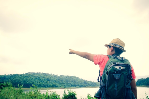 写真 空に向かってカメラを見ている男の後ろの景色