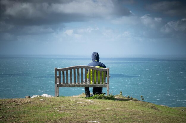 写真 空を背景に海を見ている男の後ろの景色