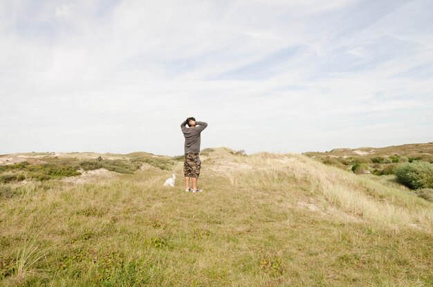 写真 天空を背景にフィールド上の男の後ろの景色