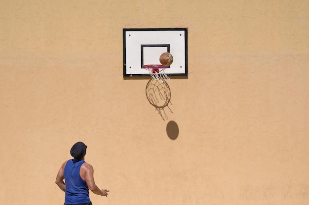 사진 벽 에 맞대고 농구를 하는 남자 의 뒷면