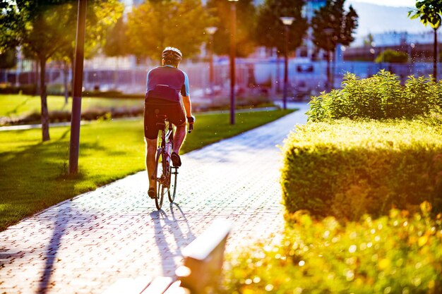 写真 公園で自転車に乗っている男の後ろの景色