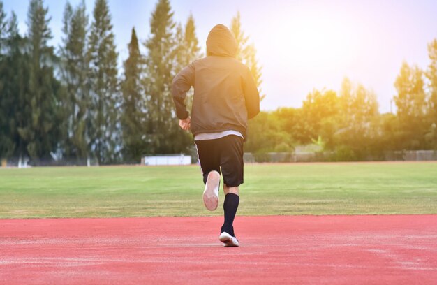 写真 樹木と空に向かってトラックで走っている男の後ろの景色