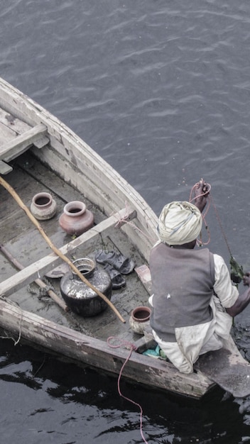 写真 湖のボートに座っている男の後ろの景色