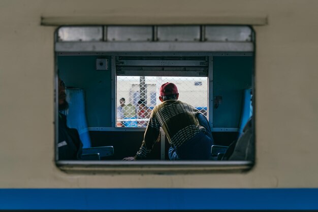 写真 列車に座っている男の後ろの景色