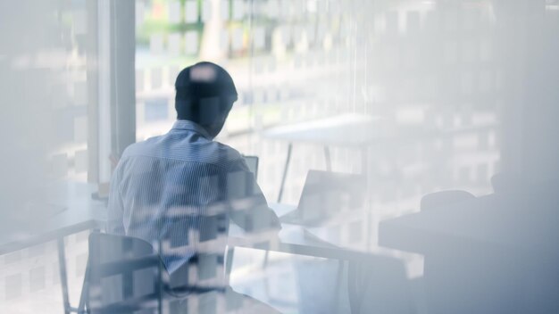 写真 窓のそばに立っている男の後ろの景色