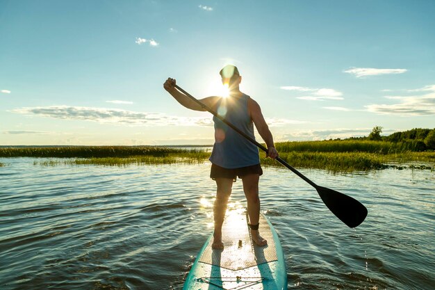 写真 空に向かって海に立っている男の後ろの景色