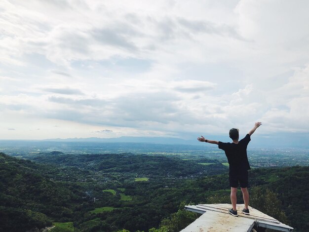 写真 天空を背景に景色に立っている男の後ろの景色