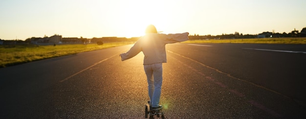 写真 夕暮れの空に向かって道路に立っている男の後ろの景色