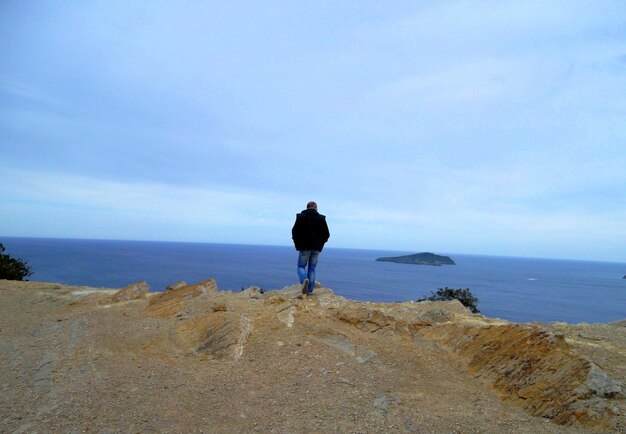 写真 海岸を歩く男の後ろの景色