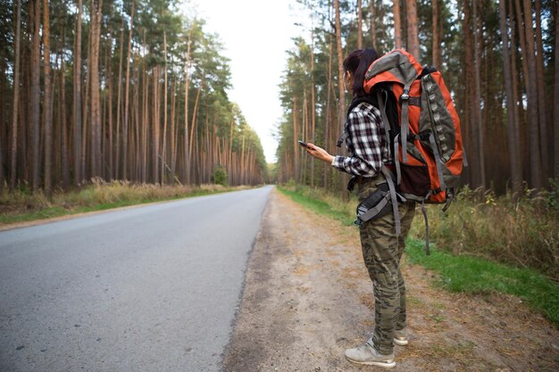 Фото Задний вид человека, идущего по дороге среди деревьев