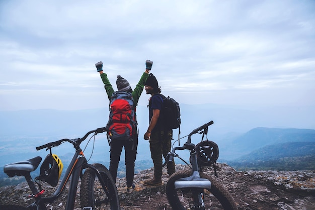 写真 天空を背景に山の上にいる男たちの後ろの景色