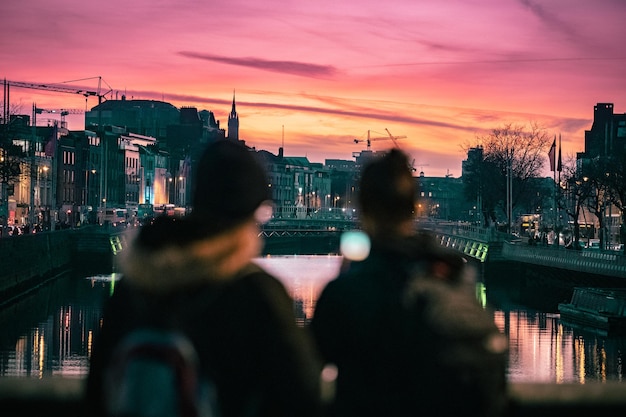 写真 夕暮れの空を背景にした都市の人々の後ろの景色