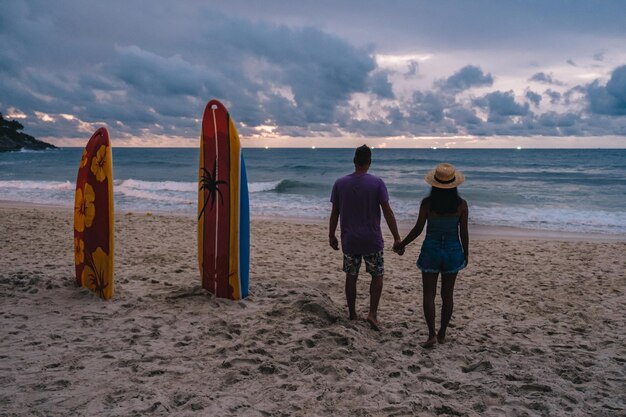 写真 空に向かってビーチにいる人々の後ろの景色