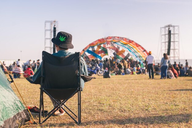 写真 空に向かってフィールドに座っている人々の後ろの景色