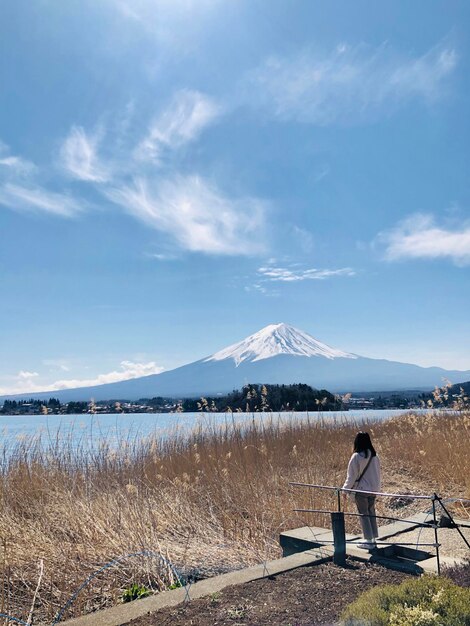 写真 空に照らされた湖の背後から見た人