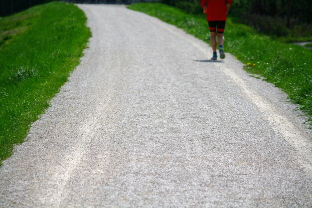 写真 道路でジョギングをしている人の後ろの景色