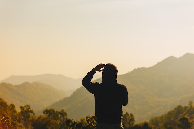 写真 山に背を向けて立っている人の後ろの景色