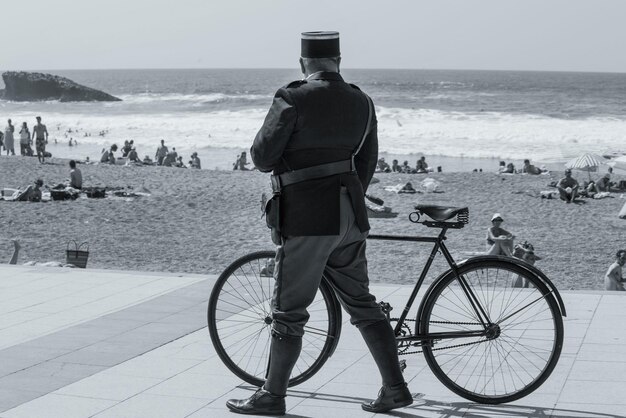 写真 ビーチで自転車で歩いている警備員の後ろの景色