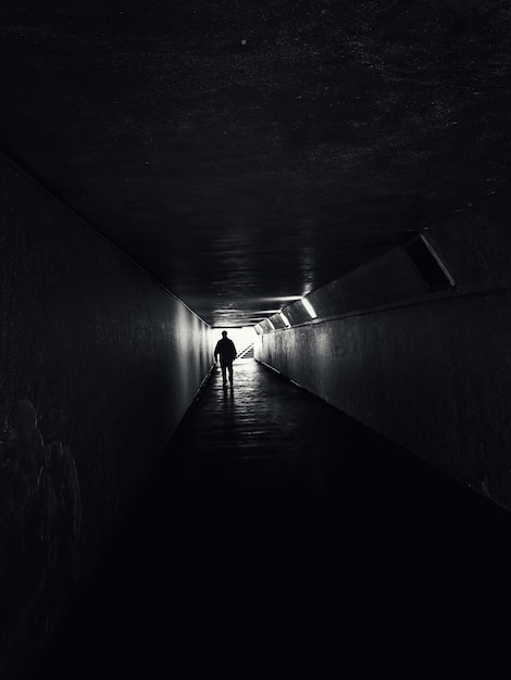 사진 조명 된 터널 에서 고 있는 실루 남자 의 뒷면