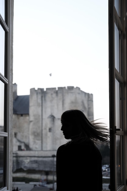 Фото Вид сзади на силуэт женщины на фоне зданий