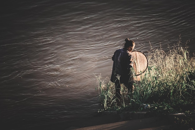 写真 湖で釣りをしている女性の後ろの景色