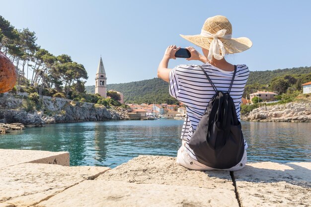 写真 天空を背景に帽子をかぶった女性の後ろの景色