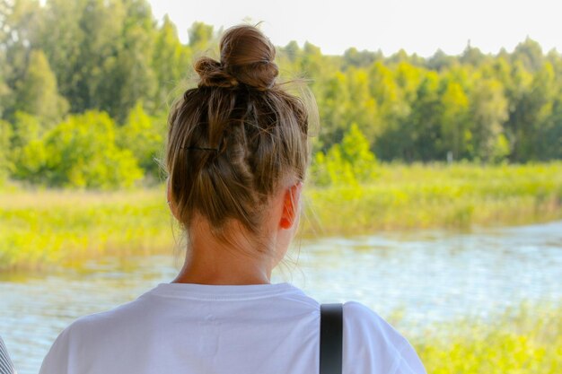 사진 나무 를 배경 으로 호수 를 바라보는 여자 의 뒷면