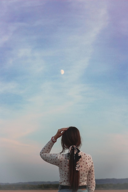 Фото Задний вид женщины, смотрящей на море на фоне неба