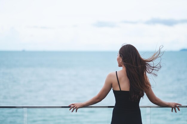 写真 空に照らして海を見つめる女性の後ろの景色