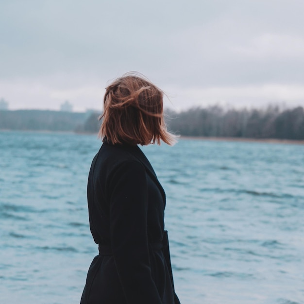 写真 海を見ている女性の後ろの景色