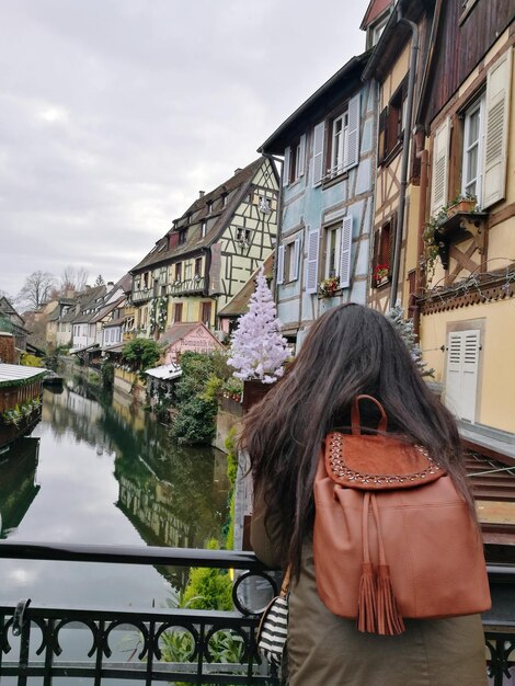 写真 空の向こうの街の運河を渡る橋の女性の後ろの景色