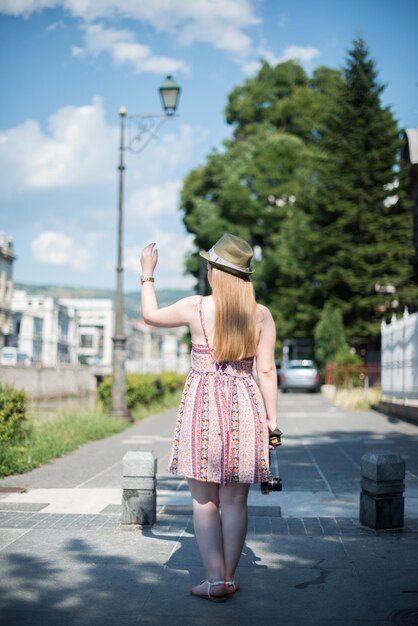 写真 街の空に照らされた道路上の女性の後ろの景色