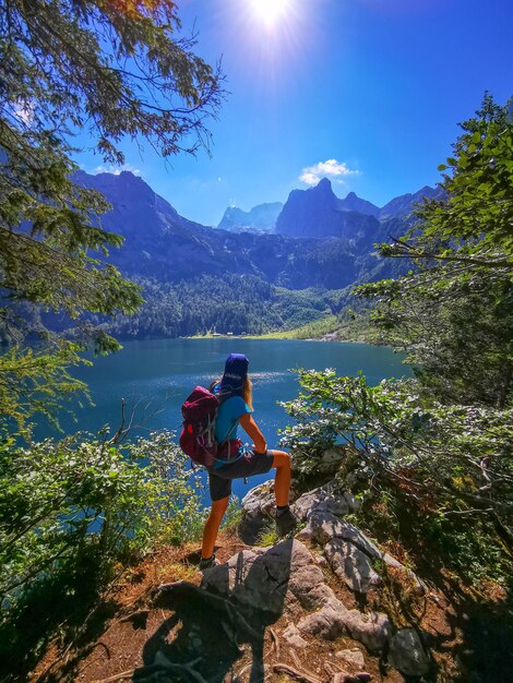 写真 天空を背景に山の岩の上にある女性の後ろの景色