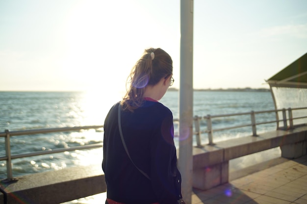 写真 静かな海を見下ろす女性の後ろの景色