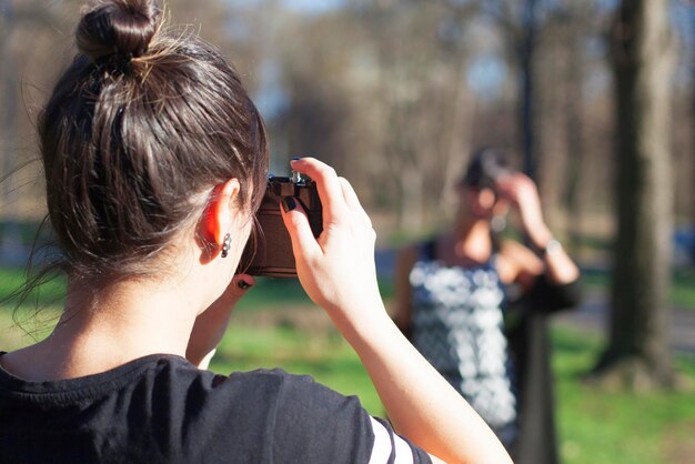 写真 友人の写真を撮っている女性の後ろの景色