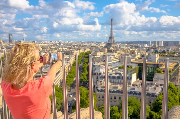 写真 歴史的な建物の写真を撮っている女性の後ろの景色