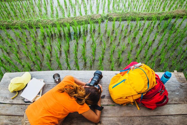 写真 農地で写真を撮っている女性の後ろの景色