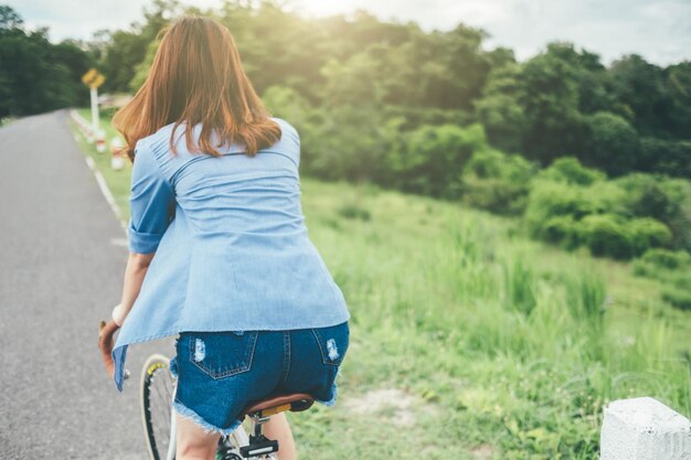 写真 道路で自転車に乗っている女性の後ろの景色