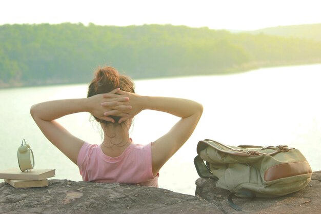 写真 川の向こうに座っている女性の後ろの景色