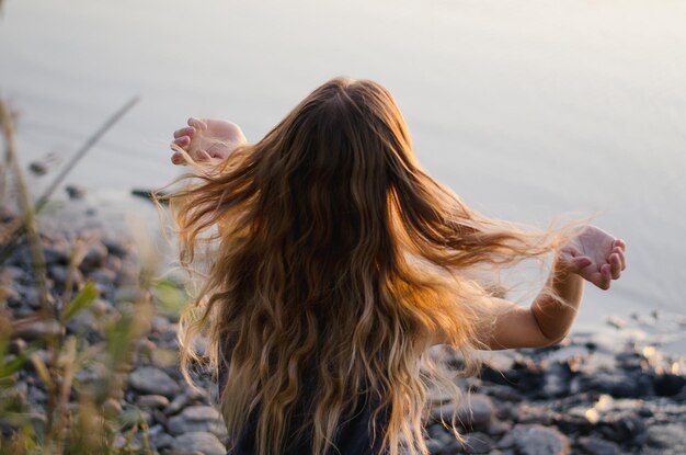 写真 湖のそばに座っている女性の後ろの景色