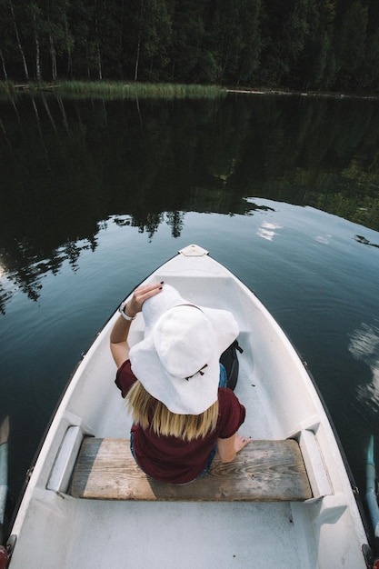 Фото Задний вид женщины, сидящей в лодке на озере