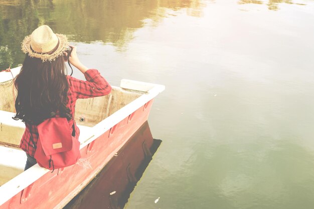 写真 湖のボートに座っている女性の後ろの景色
